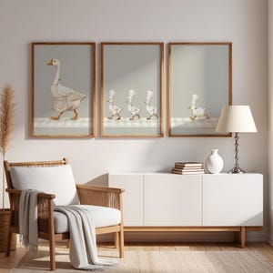 May include: Three framed wall art prints featuring illustrations of white geese. The left print shows a large goose in an apron. The middle print shows three small goslings in chef hats. The right print shows a single small gosling in a chef hat.