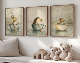 May include: Three framed watercolour prints depict a bunny, hedgehog, and mouse rowing in teacups. The prints have a soft, muted colour palette and a vintage aesthetic. Ideal for a nursery or children's room, the prints are framed in wooden surrounds.