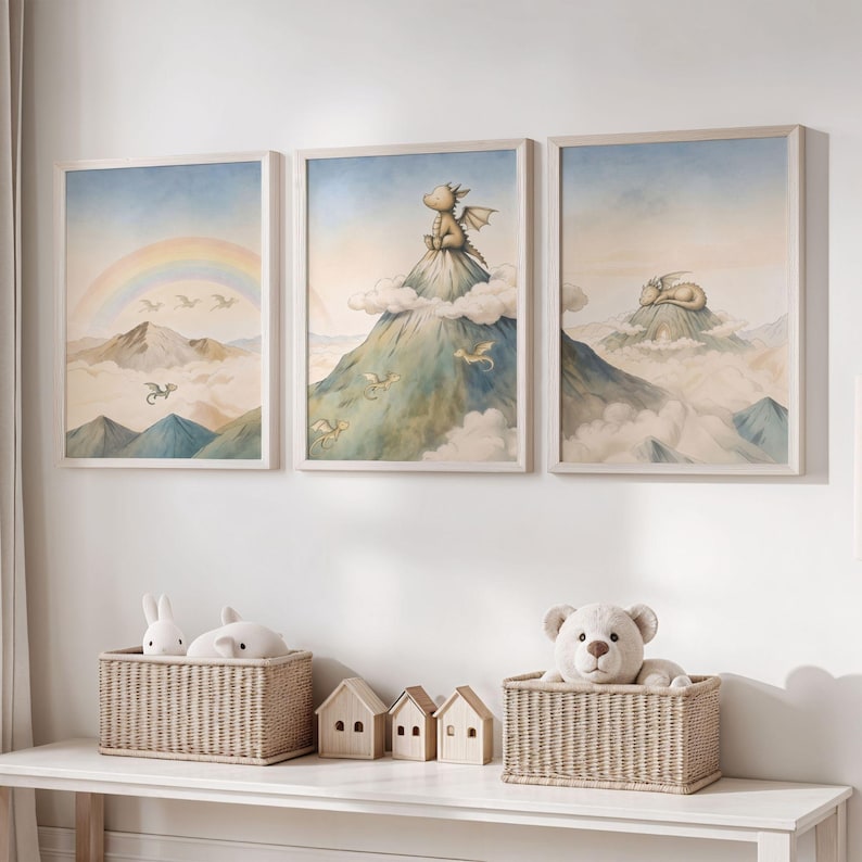 May include: Three framed watercolour prints with a dragon theme. One shows a rainbow over mountains, another a dragon on a mountain, and the third a sleeping dragon. The frames are light-coloured.