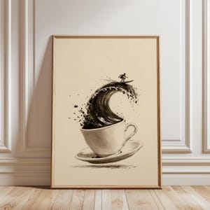 May include: A framed wall art print featuring a black and white ink-style illustration of a coffee cup on a saucer. A large, curling ocean wave rises from the cup, with a small figure of a person surfing on the crest of the wave.
