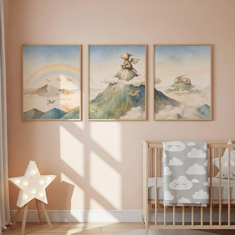 May include: Three framed watercolour prints with dragon illustrations. One shows a rainbow over mountains, another a dragon on a peak, and the third a sleeping dragon. The prints are in a nursery setting, with a cot and star-shaped lamp.