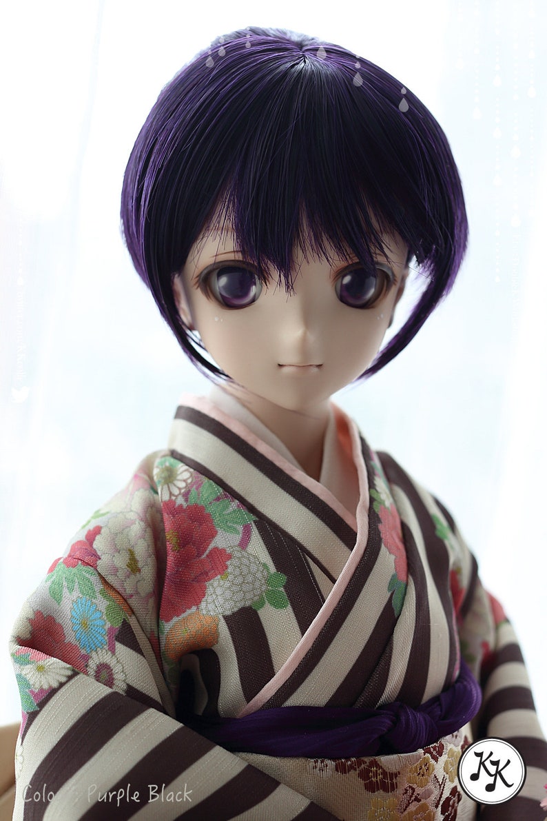 Puede incluir: Una mu&ntilde;eca con cabello morado que lleva un kimono japon&eacute;s tradicional con un patr&oacute;n floral y una faja morada. El kimono tiene rayas marrones y blancas. La mu&ntilde;eca tiene ojos morados y un tono de piel claro.