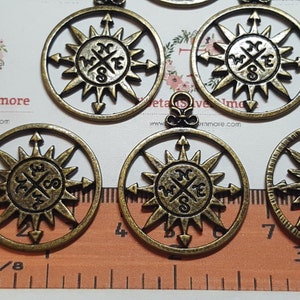 Puede incluir: Cinco abalorios de brújula de color dorado antiguo con un diseño de estrella y las letras N, S, E y W. Los abalorios miden aproximadamente 2,5 cm de diámetro.