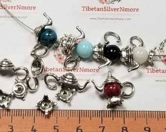 18 pares por paquete. 20 cuentas de 15 mm para tetera. Tapa con cuenta de 7-8 mm en color plata antigua. Sin plomo.