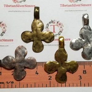May include: Three metal flower charms in gold, silver, and copper tones. Each charm has a loop for attaching to jewellery or other crafts. The charms are approximately 1 inch in size.