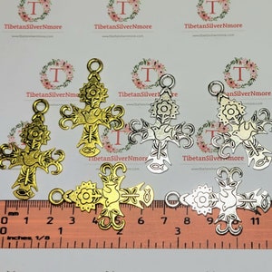 May include: Five metal cross charms with a dove and floral design. The charms are approximately 1 1/2 inches tall and are available in silver and gold finishes.