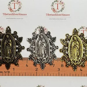 Puede incluir: Tres dijes de metal con la imagen de la Virgen Mar&iacute;a en acabado dorado, plateado y dorado antiguo. Los dijes miden aproximadamente 5 cm de di&aacute;metro y tienen un dise&ntilde;o floral detallado.
