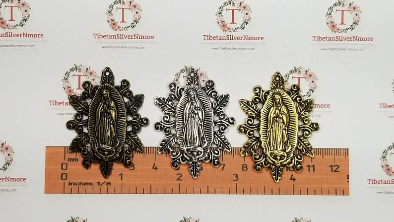 Puede incluir: Tres dijes de metal con la imagen de la Virgen Mar&iacute;a en acabado dorado, plateado y dorado antiguo. Los dijes miden aproximadamente 5 cm de di&aacute;metro y tienen un dise&ntilde;o floral detallado.