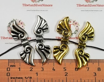 4 szt. w opakowaniu 43 x 13 mm Koraliki w kształcie skrzydeł anioła Wykończenie w kolorze antycznego srebra lub złota Cyna bez ołowiu