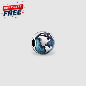 Könnte beinhalten: Ein silberner Charm-Anhänger mit einem Globus-Design. Der Anhänger zeigt weiße Kontinente vor einem blauen Ozeanhintergrund mit wellenartigen Mustern. Der Text "BUY 2 GET 1 FREE" befindet sich oben links.