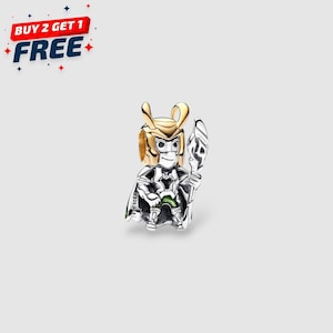 Puede incluir: Un charm de plata y oro que representa un personaje con un casco con cuernos, una capa y un bastón. El charm tiene un acento verde y el texto "S925 ALE". La imagen también incluye el texto "BUY 2 GET 1 FREE".