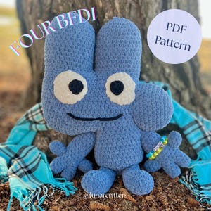 May include: A light blue crocheted plush toy of the character "Four" from BFDI. It features large white eyes with black pupils, a smiling mouth, and a small bracelet. The image also includes the text "FOUR BFDI" and "PDF Pattern".
