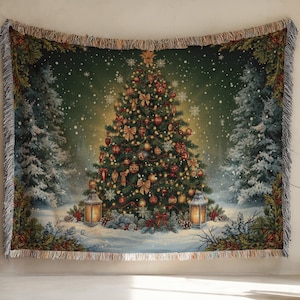 May include: A rectangular woven throw blanket featuring a central decorated Christmas tree with gold ornaments, ribbons, and a star topper. The scene includes two glowing lanterns at the base, snow-covered pine trees, and falling snowflakes.