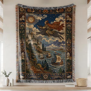 May include: A woven tapestry throw blanket featuring a detailed illustration of a figure riding a large wolf over a castle and sea with sailing ships. The design includes a sun, stars, and decorative borders with horses and swans, finished with fringe.