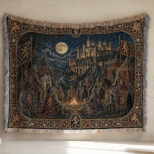 May include: A woven tapestry blanket featuring a medieval scene with knights gathered around a campfire at night. The design includes a large castle on a hill, a full moon, and heraldic flags. The border is dark blue with gold floral motifs.