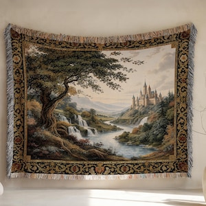 Puede incluir: Tapiz tejido que representa un paisaje con un castillo, cascadas y un gran árbol. El tapiz tiene un borde negro con motivos florales y bordes con flecos. La paleta de colores incluye tonos de verde, marrón y beige.