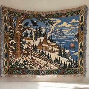 May include: A woven tapestry blanket featuring a winter landscape with a snow-covered village, a wooden Viking ship on a blue lake, and two black ravens perched on a tree. The border displays pine trees, berries, and intricate knotwork patterns.