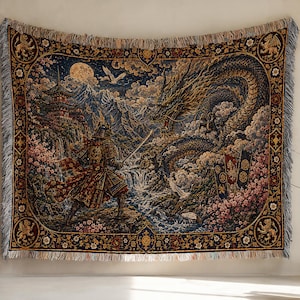 Puede incluir: Una manta de tapiz tejida que presenta una escena detallada de un samurái frente a un gran dragón en un paisaje montañoso con una pagoda, luna llena y flores de cerezo, enmarcada por un borde decorativo con flecos en todos los lados.