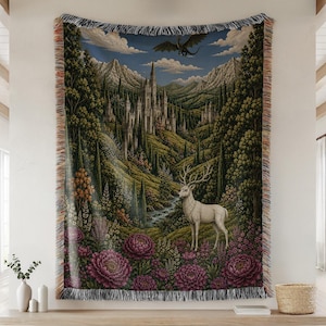 Puede incluir: Un tapiz tejido que representa un paisaje de fantasía con un ciervo blanco, un castillo y un dragón. La obra de arte representa un valle con un río, montañas y vegetación exuberante. El tapiz tiene un borde con flecos y es principalmente verde, azul y morado.