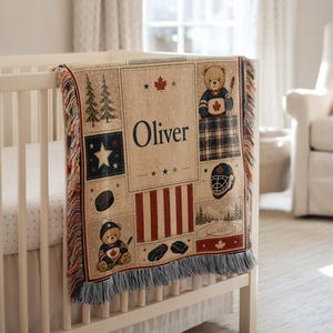 May include: A woven throw blanket featuring the name Oliver, hockey-themed illustrations including teddy bears in jerseys, a hockey puck, a helmet, gloves, a rink, pine trees, stars, and a maple leaf, finished with a fringed edge on the top and bottom.