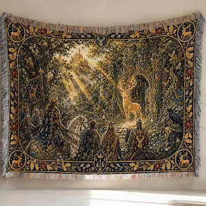 May include: A woven tapestry blanket featuring a detailed scene of a golden stag standing before a stone archway in a forest. A group of figures on horseback and a distant castle are visible. The border includes deer motifs and oak leaves.