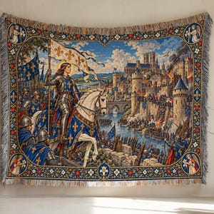Puede incluir: Un tapiz tejido que presenta una escena histórica de una figura con armadura plateada montando un caballo blanco, sosteniendo una bandera blanca con símbolos de flor de lis dorados. El fondo muestra un castillo medieval, soldados y un río, enmarcado por un borde decorativo con motivos florales y ángeles en las esquinas.