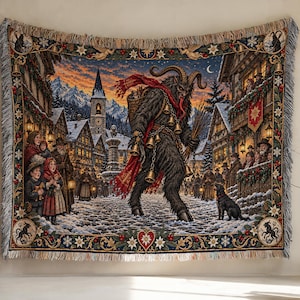 May include: A woven tapestry blanket featuring a detailed scene of Krampus walking through a snow-covered village square at night. The central figure is a dark, horned creature with bells and a basket, surrounded by villagers, buildings, and mountains.