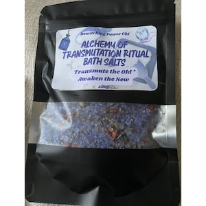 Może przedstawiać: Czarna torebka strunowa zawierająca 200g fioletowej soli do kąpieli z suszonymi roślinami. Etykieta zawiera napis: Bewitching Power Chi, ALCHEMY OF TRANSMUTATION RITUAL BATH SALTS, Transmute the Old, Awaken the New, oraz ilustracje butelki i kuli.