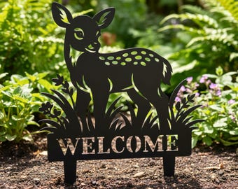 Könnte beinhalten: Schwarzer Metall-Gartenstecker mit einer Hirschsilhouette und einem Willkommensschild. Der Hirsch hat ein gepunktetes Muster und ist von ausgeschnittenem Gras und Blumen umgeben. Das Wort "WELCOME" ist am unteren Rand des Steckers ausgeschnitten.