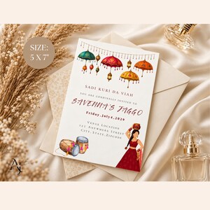 May include: A 5 x 7 inch invitation card featuring watercolor illustrations of hanging umbrellas, lanterns, and dhol drums. The text reads SADI KURI DA VIAH, YOU ARE CORDINALLY INVITED TO SAVENNA'S JAGGO, Friday, July 4, 2029, and venue location details.