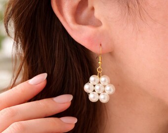 Orecchini pendenti classici a forma di fiore con perle bianche.