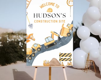 Peut inclure: Panneau de bienvenue pour le chantier de construction de Hudson, avec une illustration à l'aquarelle de véhicules et d'outils de construction. Le panneau est affiché sur un chevalet, avec des ballons blancs en arrière-plan.