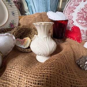 May include: A set of three ceramic mugs with a speckled, matte finish. The mugs are in shades of cream, light gray, and dark gray. Each mug has a simple, minimalist design, perfect for coffee or tea.