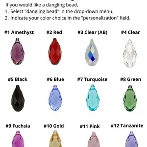 May include: Twelve different colored teardrop-shaped beads, numbered 1 through 12, for adding to jewelry. The beads are amethyst, red, clear, clear (AB), black, blue, turquoise, green, fuchsia, gold, pink, and tanzanite.
