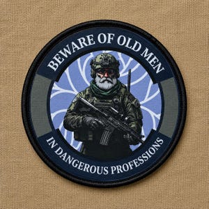 May include: A circular embroidered patch featuring a bearded soldier in tactical gear holding a rifle. The text BEWARE OF OLD MEN IN DANGEROUS PROFESSIONS is printed in white along the dark blue border against a light blue background with white lines.