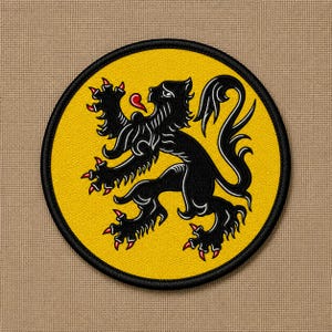 May include: A circular embroidered patch featuring a black lion rampant with red claws and a red tongue, centered on a vibrant yellow background. The design is enclosed by a thick black stitched border, creating a clean and defined edge.