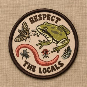 May include: A circular embroidered patch with a cream background and dark brown border. It features a green frog, a moth, a worm, a ladybug, a fly, and a pill bug. The text "RESPECT THE LOCALS" is printed in dark brown letters around the insects.