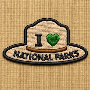 May include: Embroidered patch featuring a ranger hat design with the text "I ❤️ NATIONAL PARKS." The hat is tan with a black outline, a brown band, and a green heart. The text is in black.