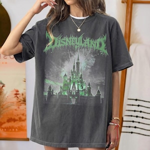 May include: Dark gray t-shirt featuring a green and white graphic of a castle with the text "DISNEYLAND" in a distressed font. The graphic tee has a vintage look and a relaxed fit.