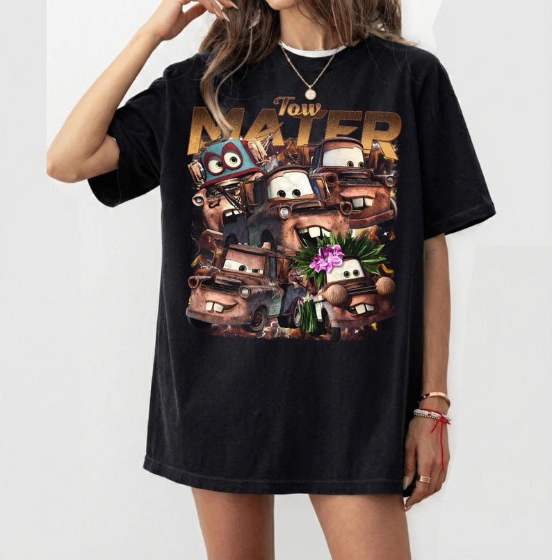 Puede incluir: Camiseta negra con un gr&aacute;fico del personaje Tow Mater de la pel&iacute;cula Cars. El dise&ntilde;o incluye m&uacute;ltiples im&aacute;genes de Mater con la palabra "Tow Mater" en letras doradas encima de las im&aacute;genes del personaje.