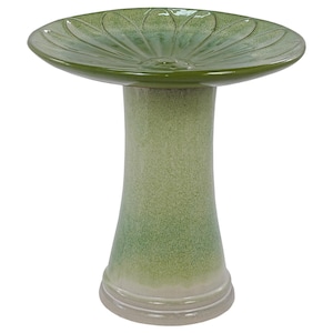 May include: A green ceramic bird bath with a pedestal base. The bowl has a scalloped edge and a floral design in the center. The pedestal is a light green color with a darker green gradient. The base is a light beige color.