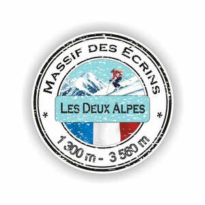 May include: A circular sticker with a black border, displaying the text "MASSIF DES ÉCRINS" and "LES DEUX ALPES". It features a skier on a snowy mountain and the French flag. The altitude range is 1,300 m - 3,560 m.