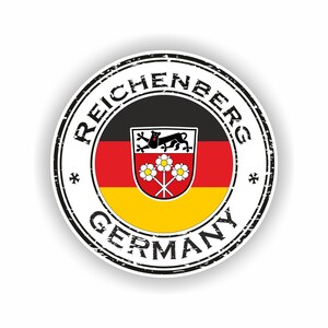 Puede incluir: Una pegatina redonda con un borde negro desgastado. El texto "REICHENBERG GERMANY" está dispuesto en círculo. El centro muestra un escudo de armas sobre un fondo negro, rojo y amarillo.