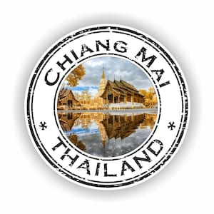 May include: Round sticker with a photograph of a Thai temple and its reflection in water. The sticker has a black border with the words "CHIANG MAI THAILAND" in a circular pattern.