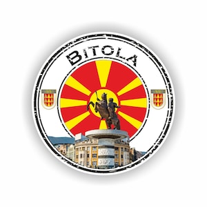 May include: A round sticker featuring the city name "BITOLA" in black, encircling a design with the North Macedonian flag's sunburst and a bronze statue of a man on a horse. Includes two crests and a cityscape.