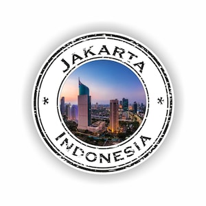 Può includere: Un adesivo circolare con un bordo nero usurato che riporta il testo JAKARTA in alto e INDONESIA in basso. Il centro mostra una vibrante fotografia dall'alto dello skyline di Giacarta al crepuscolo con alti grattacieli.