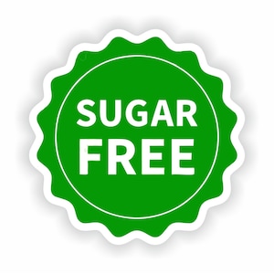 Può includere: Un adesivo verde e bianco con la scritta "SUGAR FREE" in lettere bianche in grassetto. L'adesivo ha una forma circolare con un bordo smerlato e un bordo bianco. Lo sfondo è bianco.