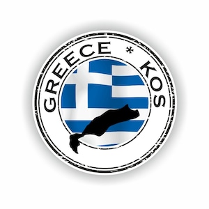 Könnte beinhalten: Ein runder Aufkleber mit der griechischen Flagge und einer schwarzen Silhouette der Insel Kos. Die Worte "GREECE * KOS" sind in einem Kreis um die Flagge und die Insel herum in einer verwitterten Schrift gedruckt.