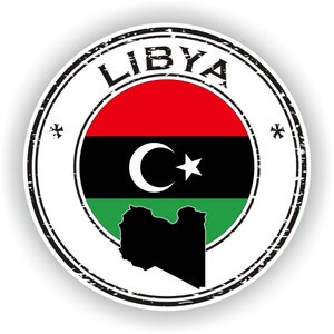 May include: A distressed, circular stamp with the word "LIBYA" in black lettering around the edge. The centre of the stamp features the Libyan flag with a black crescent moon and star on a red, black, and green background. The outline of Libya is shown in black below the flag.