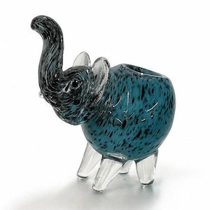 May include: A teal and black speckled glass elephant figurine with a raised trunk and clear glass legs and ears. The elephant has a hollowed-out back, suggesting it could be used as a small planter or decorative item.
